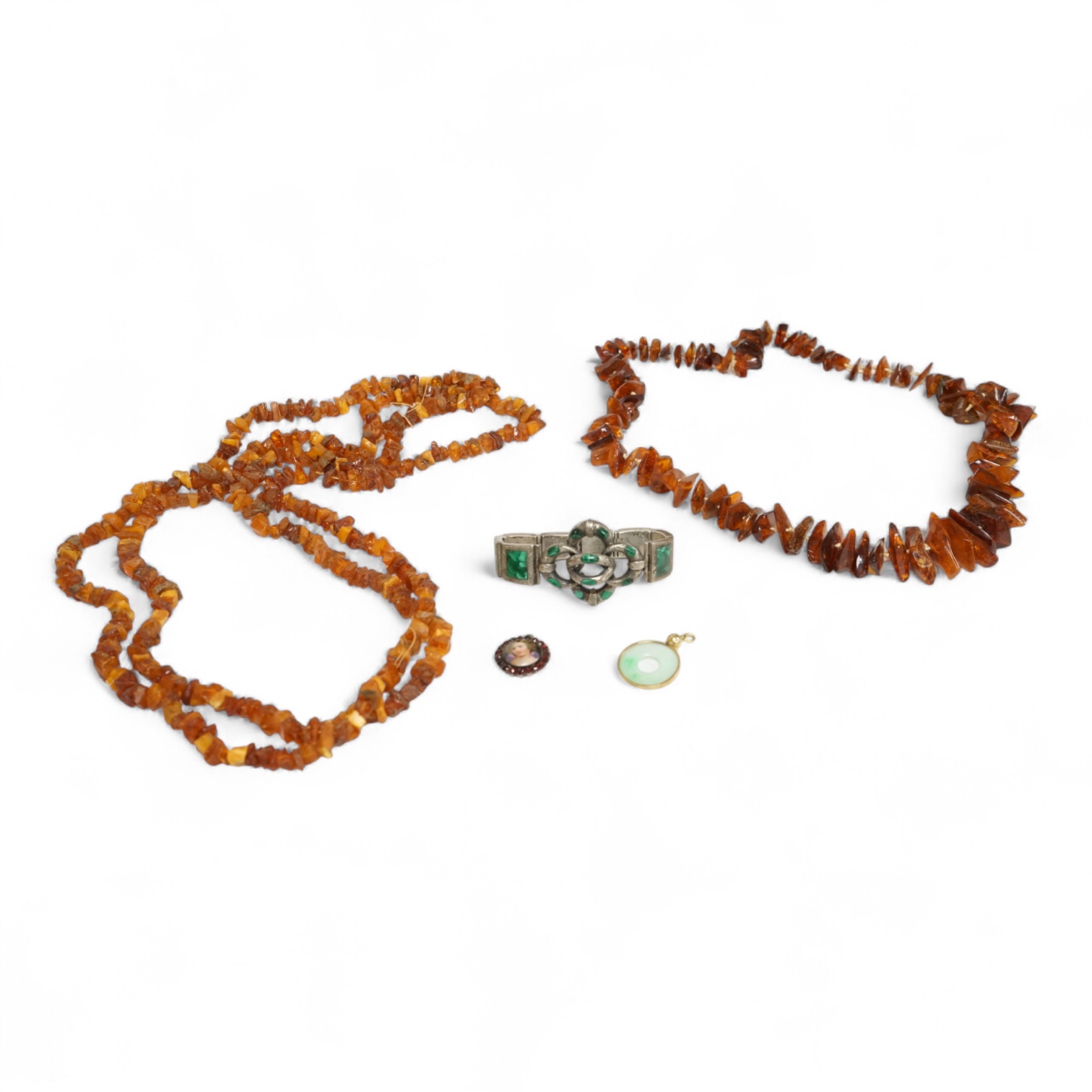 An early to mid 20th century engraved white metal and malachite set 'knot' bracelet, together with a Victorian garnet and enamel portrait pendant, a mounted jadeite disc pendant and two amber necklaces.